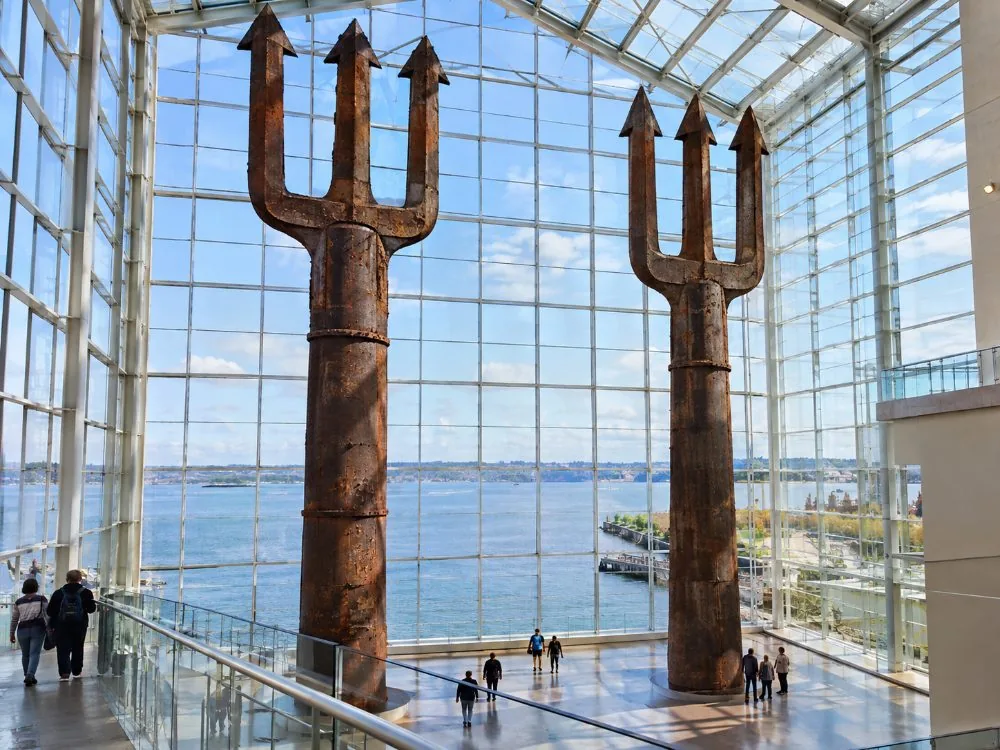 Two tall steel tridents inside a glass museum pavilion